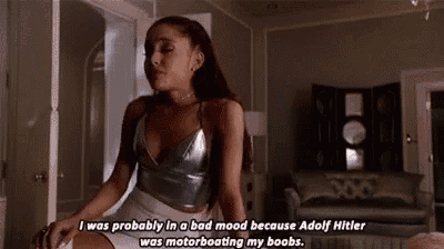 ariana grande is sitting in a living room wearing a silver top and white shorts and talking about adolf hitler .