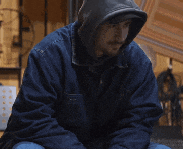 a man wearing a blue jacket with a hood on