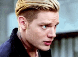 a close up of a man 's face with blonde hair looking at the camera .