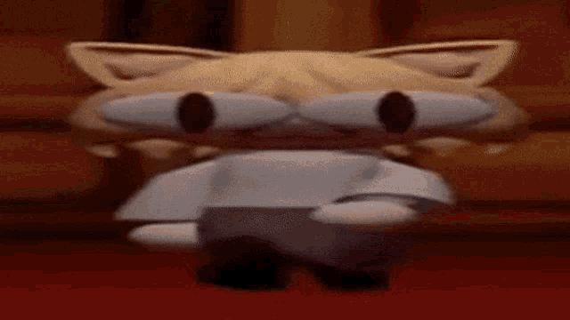 a cartoon cat is standing on a red carpet and looking at the camera .