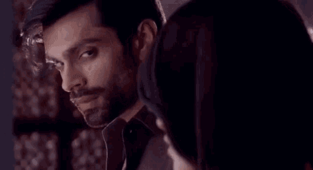 a man and a woman are looking at each other while sitting next to each other .