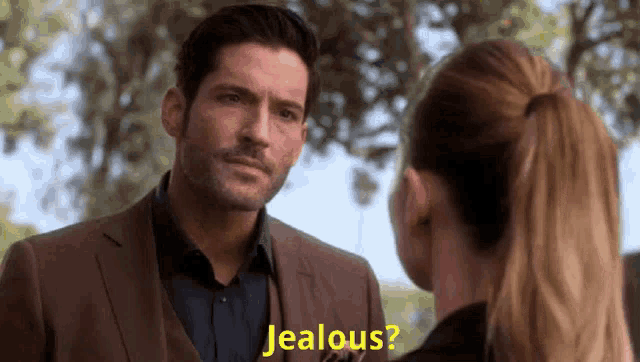 a man in a suit is talking to a woman in a ponytail who is asking him if he is jealous .