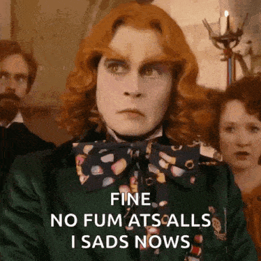 a man with red hair is wearing a green jacket and a bow tie .