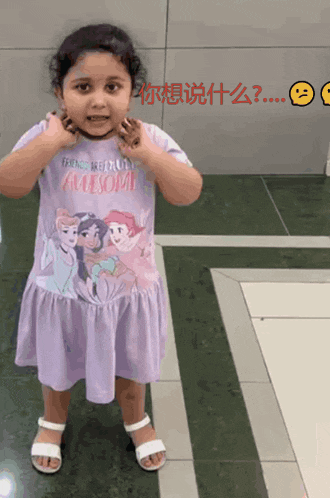 a little girl is wearing a purple disney princess shirt