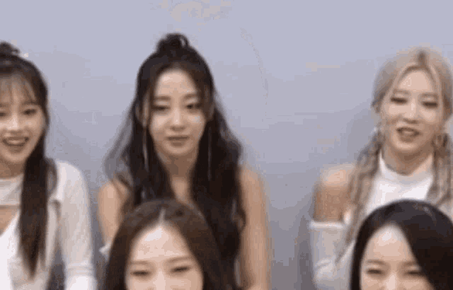 a group of women are sitting next to each other and smiling .