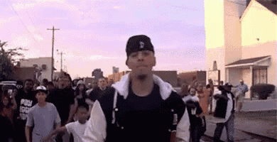 a man wearing a baseball cap with the letter d on it is standing in front of a crowd of people .