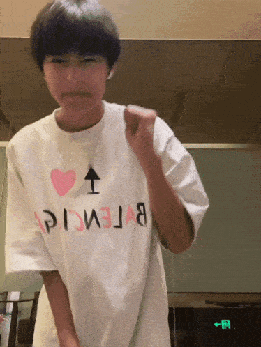 a person wearing a white t-shirt that says balenciaga