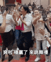 a group of people are dancing in a room with chinese writing on the bottom of the image .