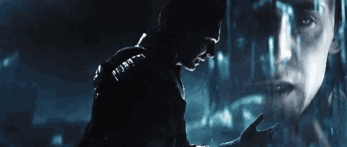 a man is standing in front of a mirror with a reflection of a woman 's face .