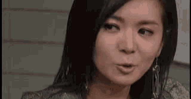 a close up of a woman making a funny face while sitting down .