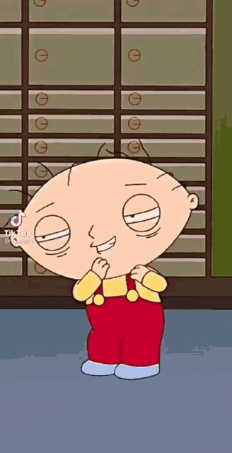 stewie from family guy is standing in front of a row of drawers .