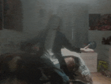 a blurry picture of a person sitting on a chair in a bedroom