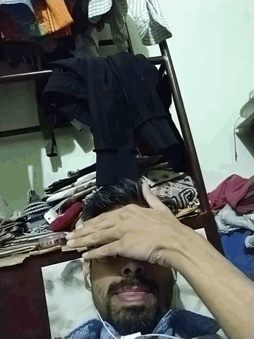 a man with a beard is laying on his back with his hand on his face