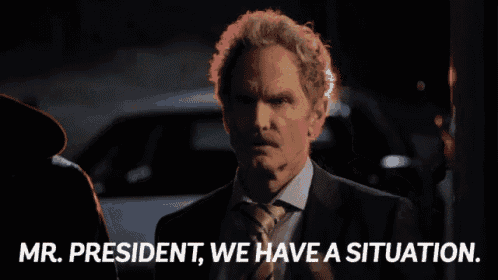 a man in a suit and tie is talking on a cell phone and says mr. president we have a situation