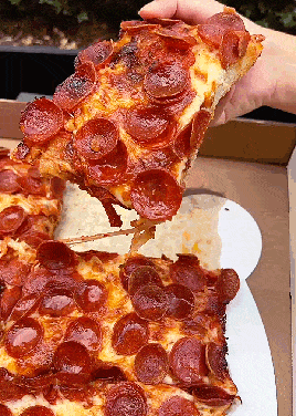 a pepperoni pizza is being taken out of a box