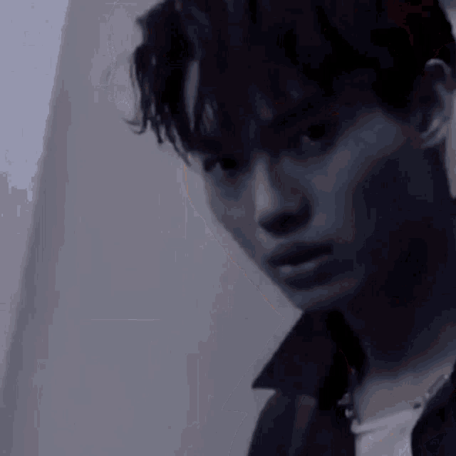 a close up of a young man 's face with a serious look on his face .