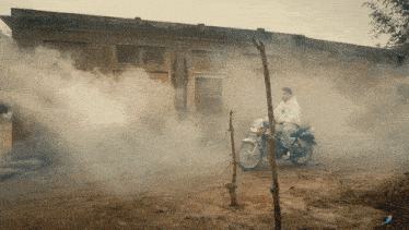 a man riding a motorcycle in a smokey area