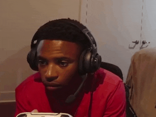 a young man wearing headphones is playing a video game
