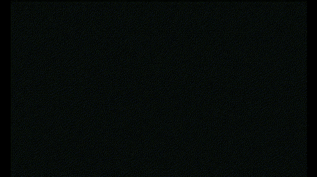 a woman with glowing eyes is standing in front of a window in a dark room .