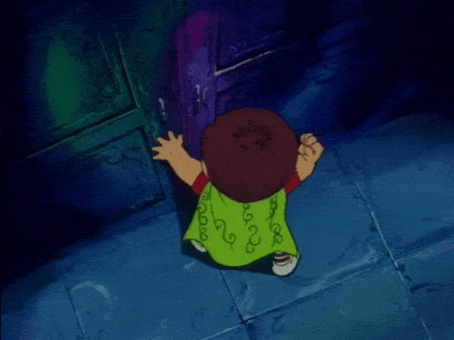 a boy in a green shirt with swirls on it is looking at a door
