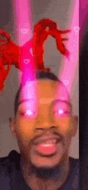 a man with a stuffed animal on top of his head is smiling .
