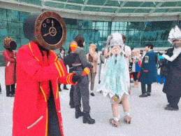a man with a clock on his head stands in a crowd of people