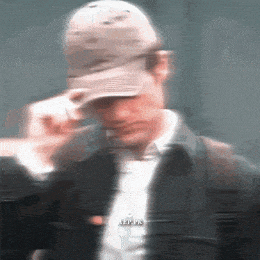 a blurry picture of a man wearing a baseball cap and a jacket