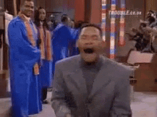 a man in a blue robe is standing in front of a group of people in blue gowns .