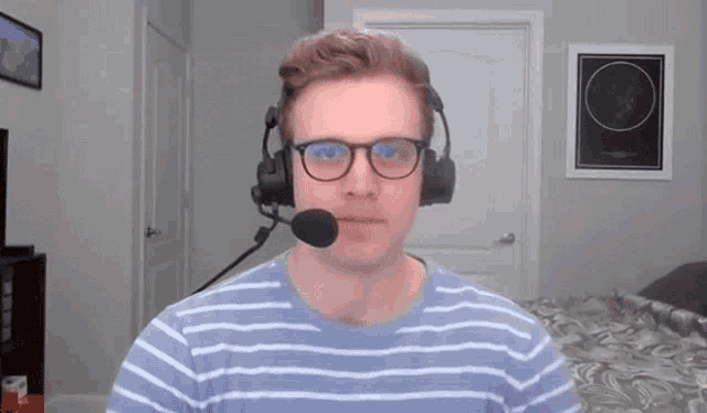 a man wearing glasses and a headset with a microphone in his mouth