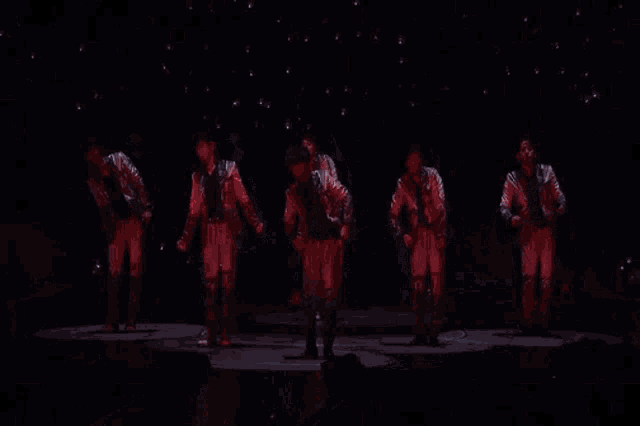 a group of men are standing next to each other on a stage .