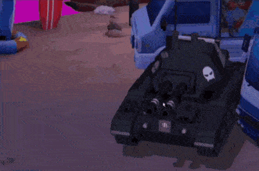 a black toy tank with a skull on the side is parked on a beach