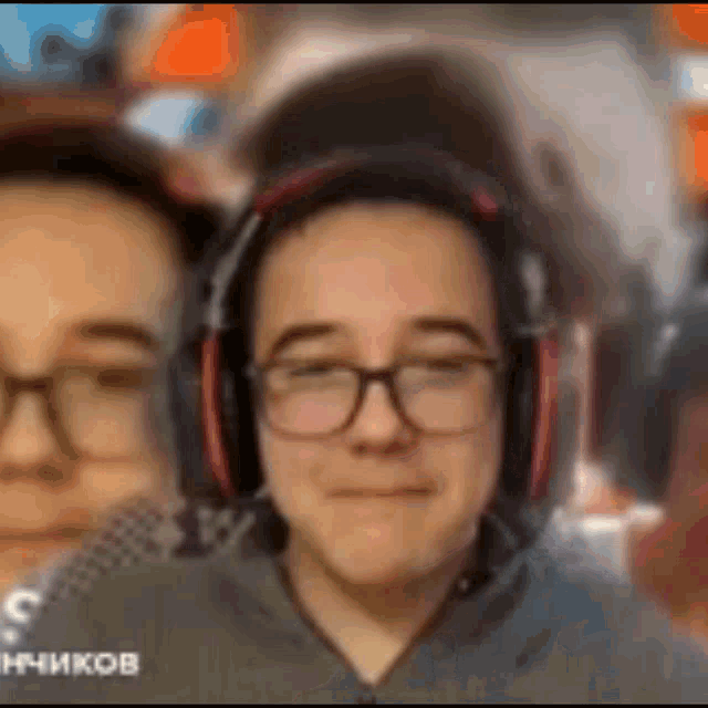 a man wearing headphones and glasses is smiling .