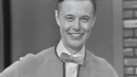 a man in a suit and bow tie is smiling in a black and white photo .