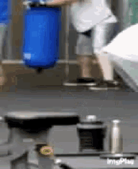 a person is holding a blue barrel in a room