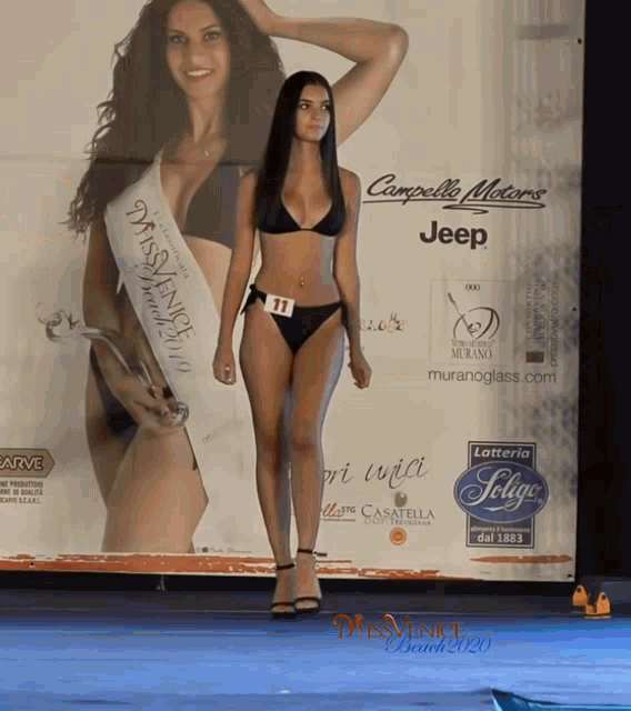 a woman in a bikini is standing in front of a jeep sign