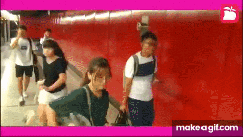 a group of people are walking down a set of stairs in a tunnel .