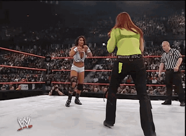 two women in a wrestling ring with the letter w on the bottom right