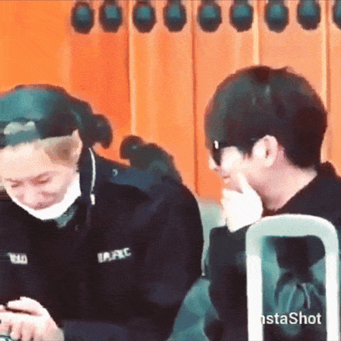 a man and a woman are sitting next to each other and laughing .