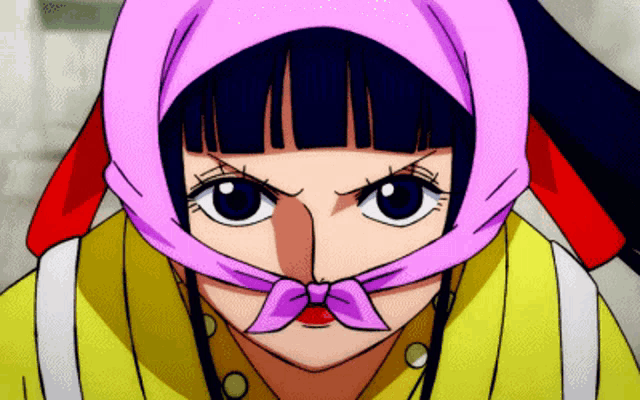 a girl with a pink scarf around her head looks at the camera