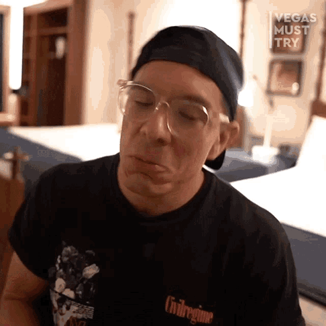 a man wearing glasses and a black shirt that says civil regime makes a face