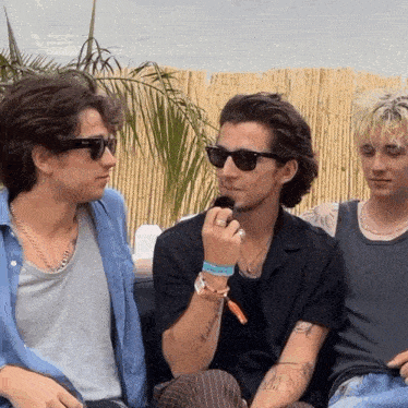 a man wearing sunglasses has a tattoo on his arm that says " i 'm a bitch "