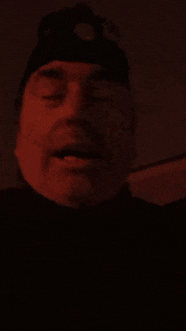 a man is wearing a headlamp on his head in a dark room