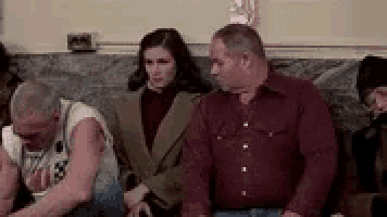 a group of people are sitting on a couch .