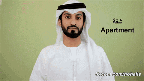 a man with a beard is standing in front of a green wall with the word apartment on it