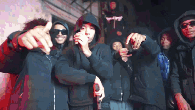 a group of people wearing black hoodies and sunglasses are posing for a photo