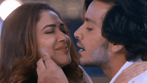 a man is kissing a woman on the forehead