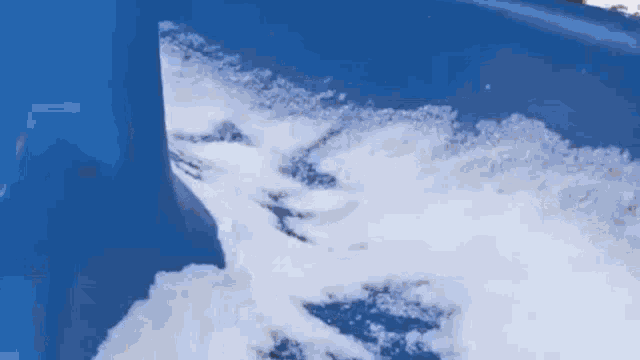 a blue bucket filled with snow is being scooped out of a blue bucket .