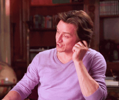 a man in a purple sweater is talking on a cell phone