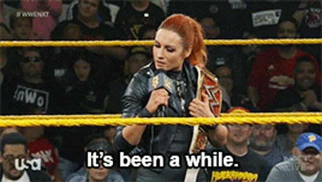 a woman in a wrestling ring says it 's been a while in front of a crowd
