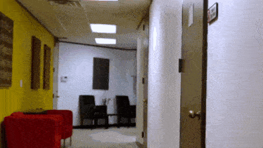 a hallway with red chairs and a sign on the wall that says ' no smoking '